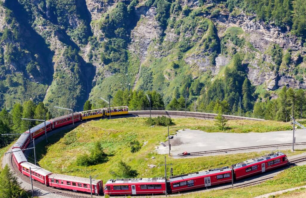 Un train Panoramique dans les montagnes alpines lors d'un itinéraire Interrail en été