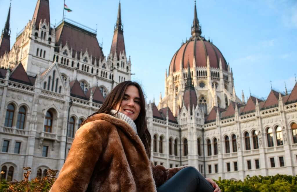 une voyageuse à Budapest posant devant le parlement lors d'un itinéraire Interrail