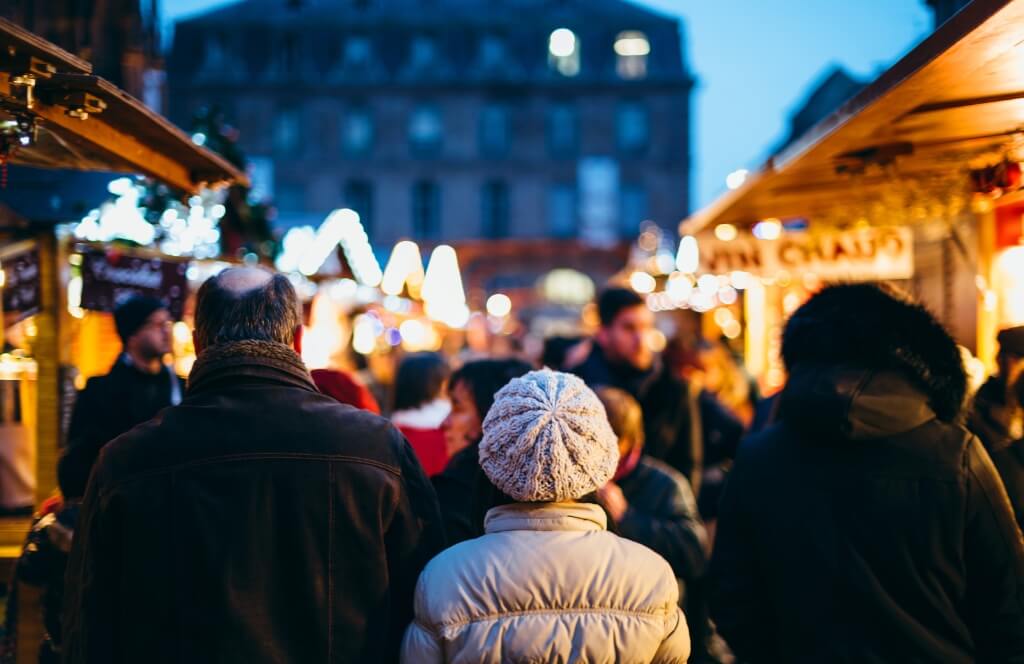 Des voyageurs dans un marché de Noël en France
