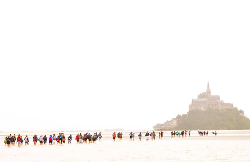 Des visiteurs traversant la marée pour rejoindre le Mont Saint Michel pour les ponts de mai